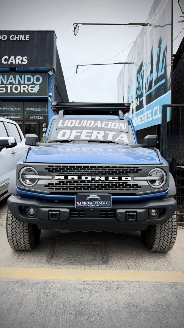 Ford Bronco azul con letrero de Liquidación Oferta en el parabrisas